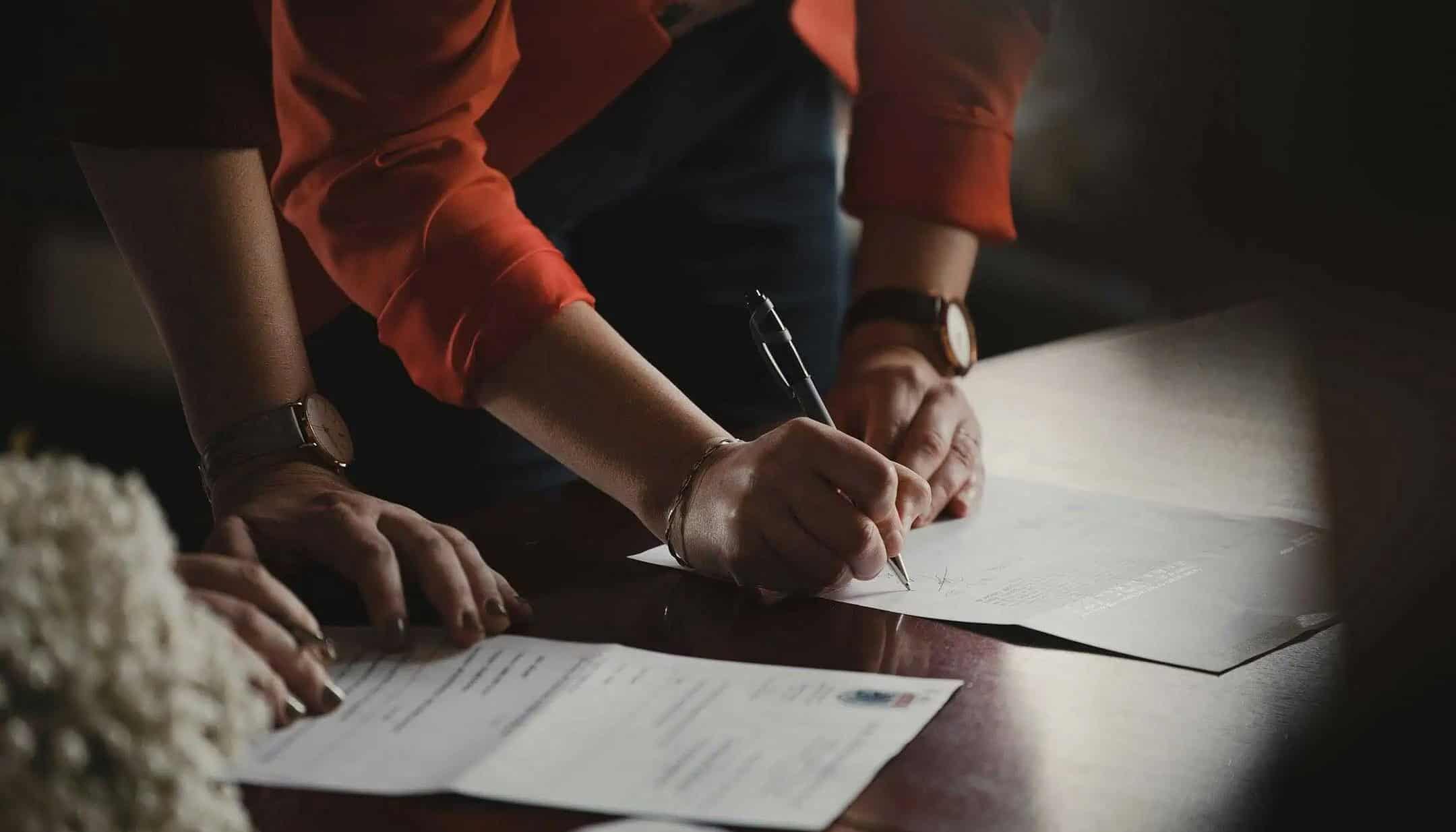 People signing legal paperwork